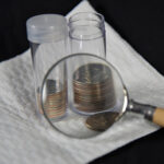 coins stored in plastic holders with magnifying glass in front